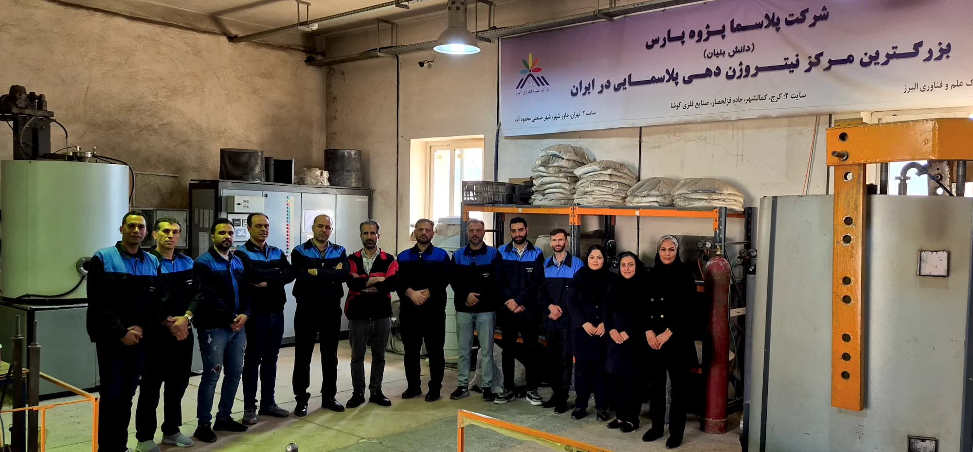 تیم پلاسما پژوه پارس در کارگاه نیتروژندهی پلاسمایی، زیر بنر بزرگترین مرکز نیتروژندهی پلاسمایی در ایران
